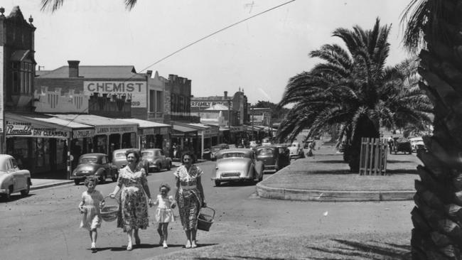 A family walks down the palm-lined main shopping area in the 1950s. Picture: HWT Argus Collection.