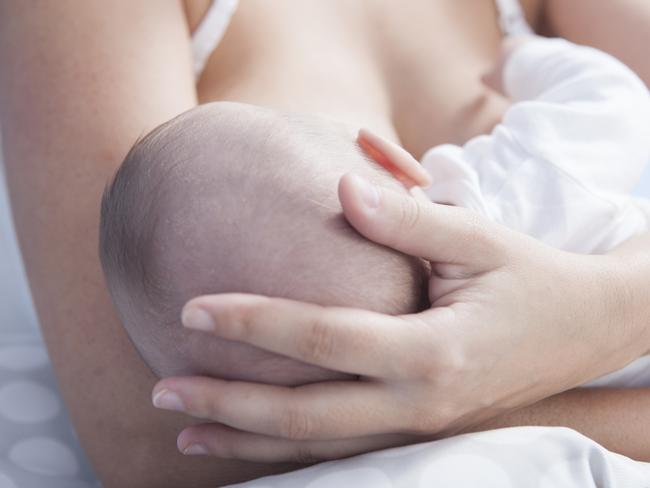 Mother holds her baby head while he is breastfed - Stock image. Breastfeeding, Baby, Mother, Women, Breast. Picture: iStock