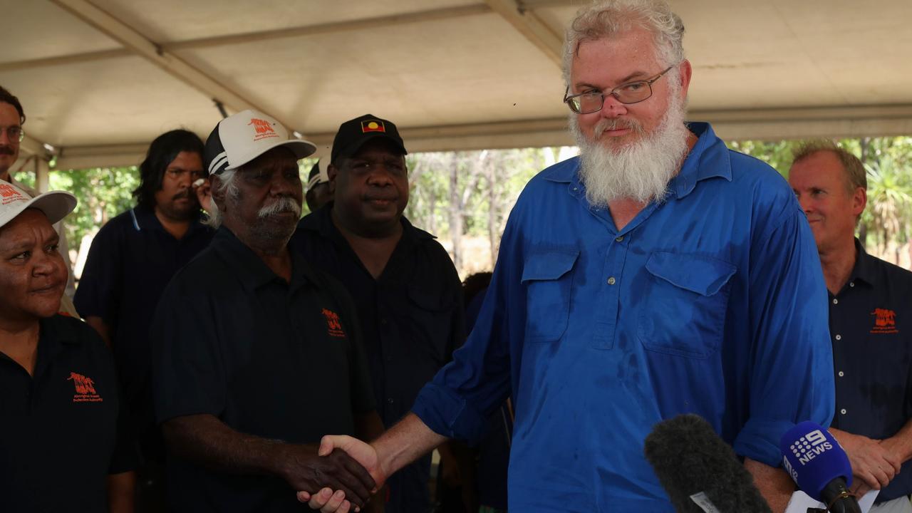 Aboriginal Areas Protection Authority chair Bobby Nunggumajbarr, right, shaking hands with Bolmo clan senior man Joseph Markham after celebrating the end of the Gunlom Falls sacred site battle, where the Director of National Parks pleaded guilty during an on Country hearing. Picture: Zizi Averill