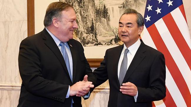 Secretary of State Mike Pompeo tries to gloss over a testy moment with Foreign Minister Wang Yi in Beijing on Monday night. Picture: AFP