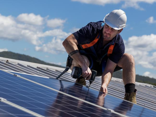 Man on roof fitting solar panels