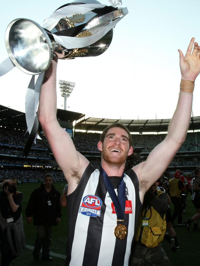 Tyson Goldsack with the premiership cup after Collingwood won the 2010 AFL grand final replay against St Kilda.