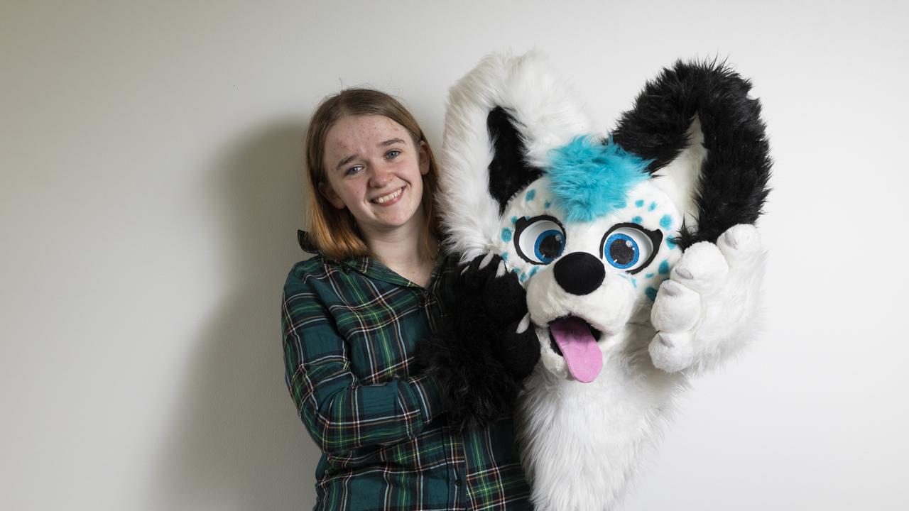 Gabi, 21, with the head of Skye, her wolfdog character, or fursona. Picture: Mark Cranitch