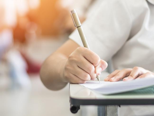 Exam with school student having a educational test, thinking hard, writing answer in classroom for university education admission and world literacy day concept