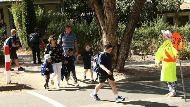 Crossing supervisor Lorron Lewis escorts students across her crossing which is due to be closed. Picture: Hamish Blair