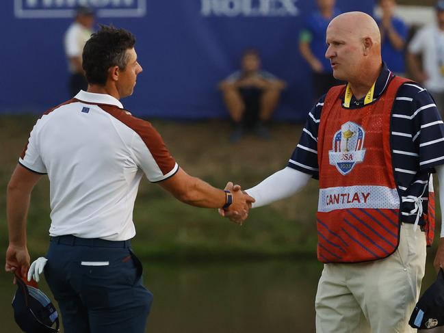 Rory McIlroy shakes hands with caddie of Patrick Cantlay, Joe LaCava. Picture: Mike Ehrmann/Getty Images