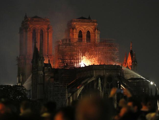 Firefighters tackle the blaze as flames and smoke rise from Notre Dame cathedral as it burns in Paris, Monday, April 15, 2019. (AP Photo/Thibault Camus)