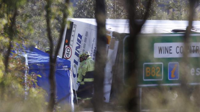 Emergency crews working to remove the bodies at the scene of the horrific bus crash, which killed 10 people and injured 25 others at Greta. Picture: Jonathan Ng