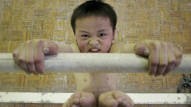 A young boy practices gymnastics at a sports school in Chengdu, China.