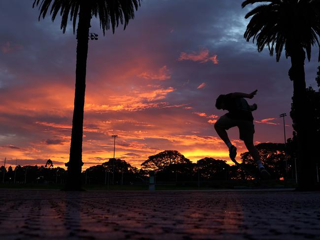 DAILY TELEGRAPH - 7 DECEMBER, 2021. A storm rolls into Sydney bringing thunder, lightning and heavy rains. A boy riding his skateboard at Moore Park is silhouetted against the sunset after the storms. Picture: Toby Zerna