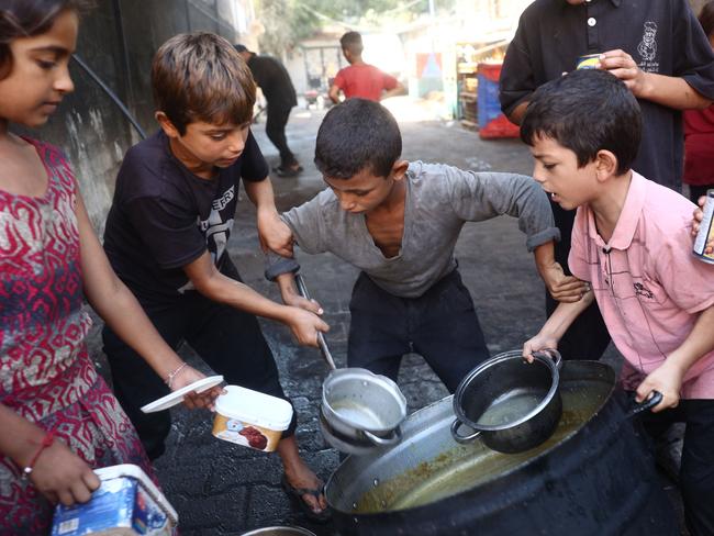 Displaced children queue up for food. Picture: Eyad Baba/AFP