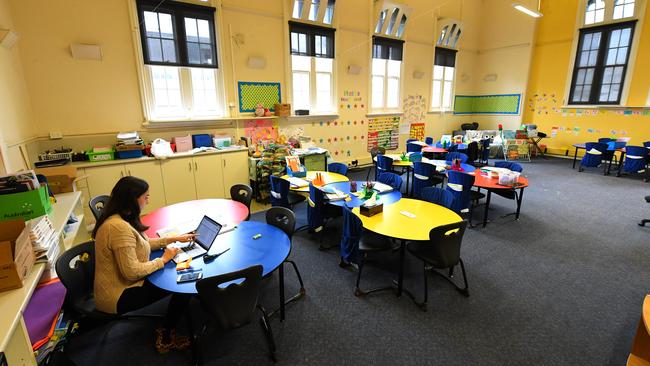 A teacher is seen in an empty class room at a primary school in Melbourne.