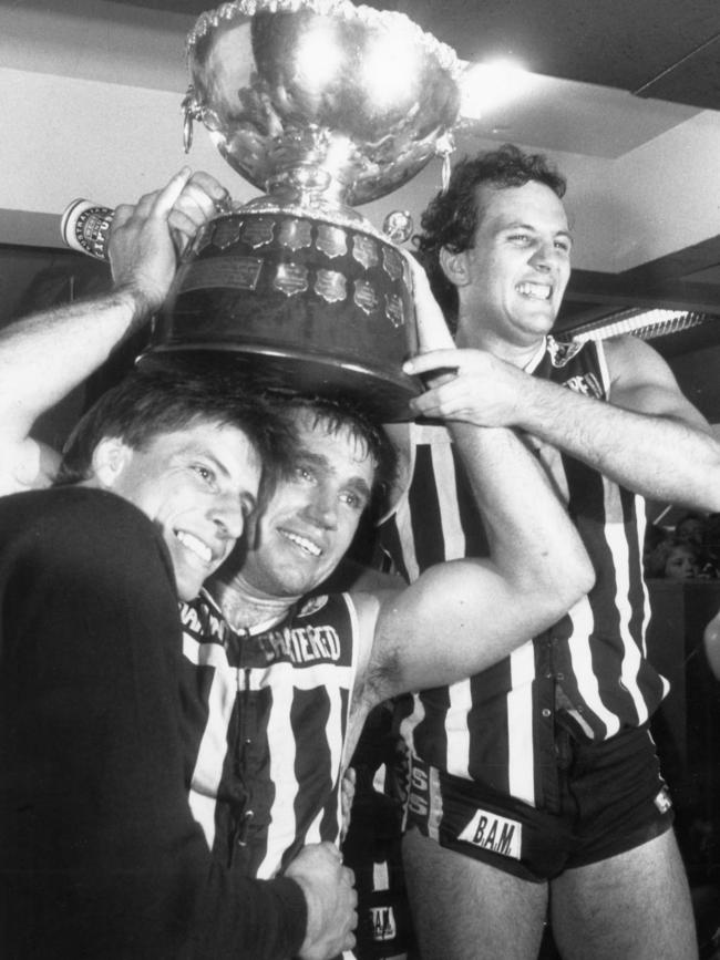 Footballers Russell Johnston, Greg Phillips and George Fiacchi holding the 1988 Thomas Seymour Hill trophy.