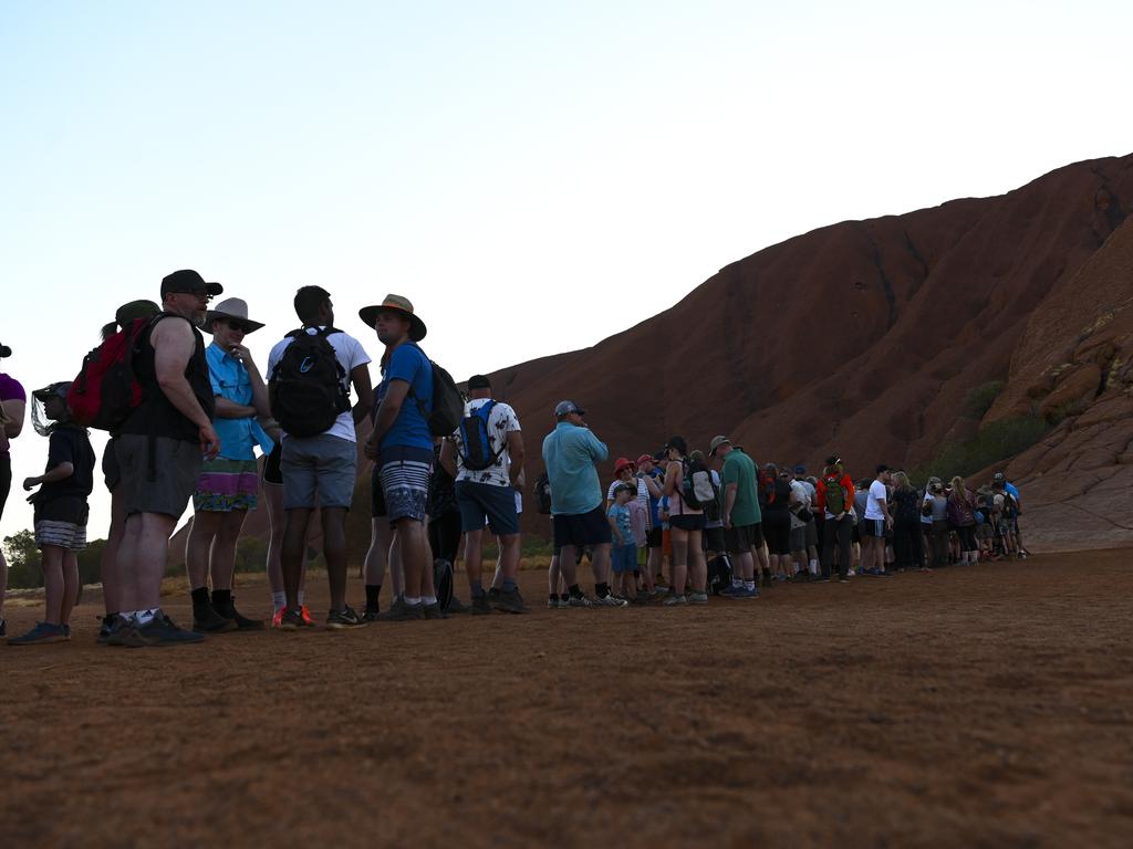 Tourists are seen lining up to climb Uluru before scaling it is banned on October 26. Picture: AAP Image/Lukas Coch