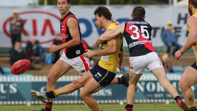 Eagles Jordan Foote kicks as West's Jack Evans tackles. Picture: AAP Image/Russell Millard