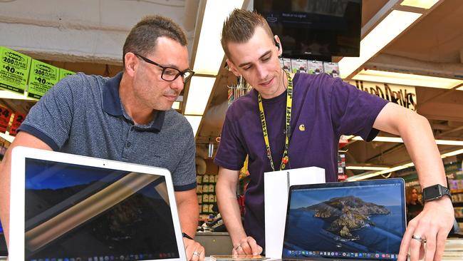 Customer Julian Anastasia from Aspley gets a helping hand from JB Hi Fi staff member Marty Meynell. Picture: AAP, John Gass.