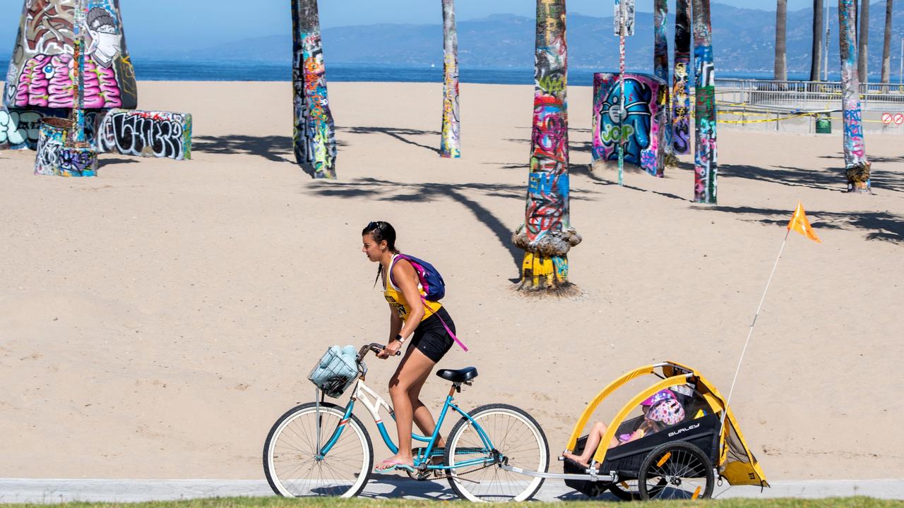 A person bikes despite the bike path being closed on the first day Los Angeles County allowed beaches to reopen after a six-week closure implemented to stop the spread. The County only allowed activities such as running, walking, swimming and surfing with sunbathing and volleyball not allowed. Picture: Valerie Macon / AFP