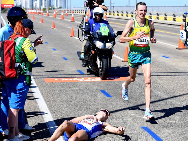 Australia’s Michael Shelley passing a prostrate Callum Hawkins of Scotland near the end of the men’s marathon was the defining image of the Gold Coast Commonwealth Games. Picture: Tracey Nearmy/AAP