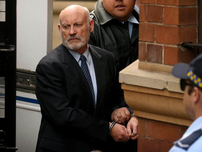 Ian Macdonald is led out of court in handcuffs after being sentenced to 10 years jail. Picture: Toby Zerna