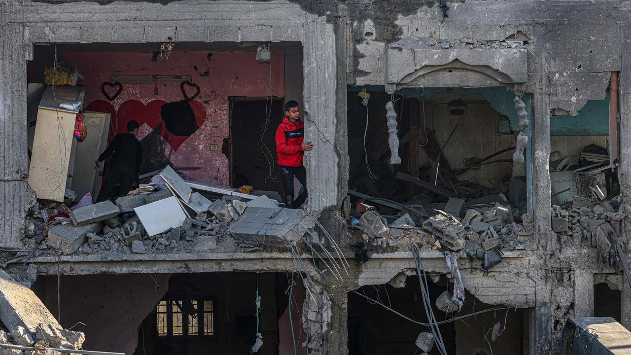 Palestinians inspect the damage in the rubble of a building where two hostages were reportedly held before being rescued during an operation by Israeli security forces in Rafah. Picture: AFP