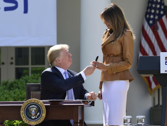 President Donald Trump gives first lady Melania Trump a pen he used to sign a proclamation, following the event. Picture: AP