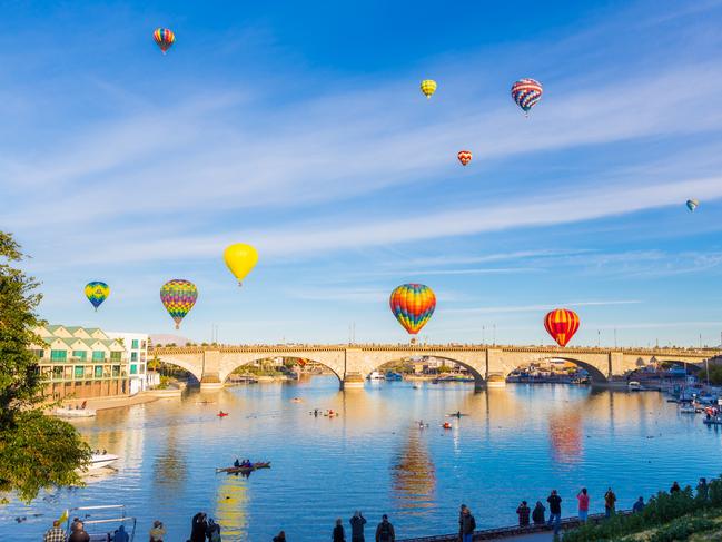 Multiple hot air balloons ascend over the London Bridge, in Lake Havasu City Arizona, during the annual the air balloon festival. Picture: iStockDoc Holiday, Escape