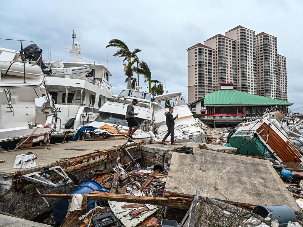 Residents inspect damage to a marina as boats are partially submerged in the aftermath of Hurricane Ian in Fort Myers. Picture: AFP