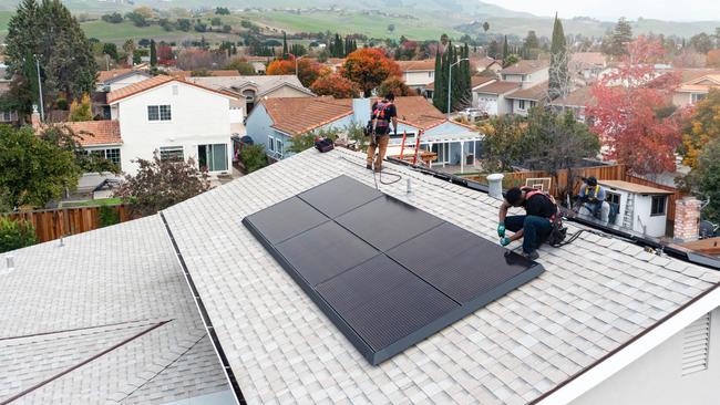 The post featured a picture of Aussie tradies installing solar panels on a roof in WA.