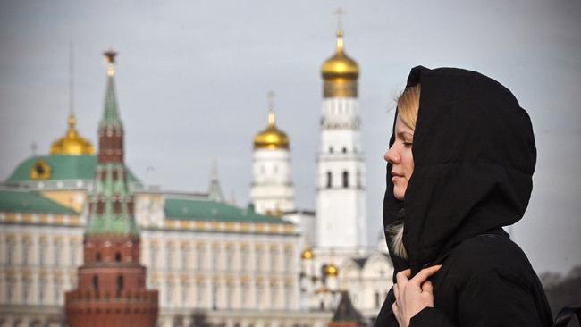 A woman crosses a bridge over the Moskva River this week with the Kremlin in the background. Picture: AFP