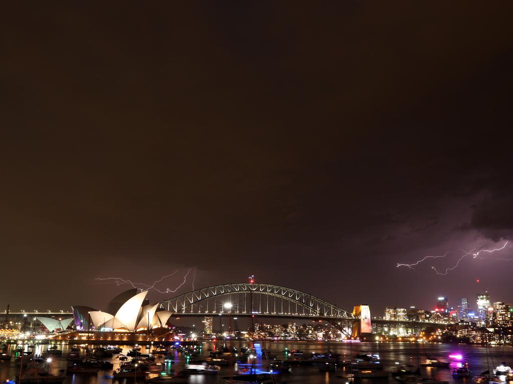 Lightning before the New Year's Eve 9pm fireworks over Sydney Harbour as seen from Mrs Macquarie's Chair. Picture: Jonathan Ng