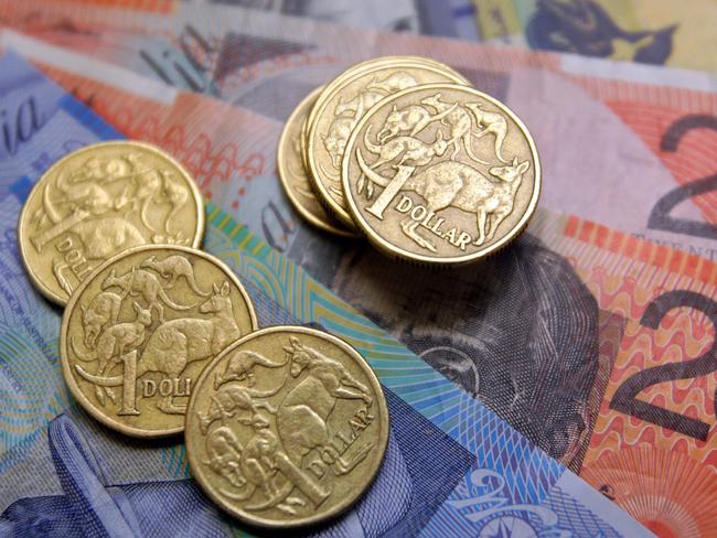 Australian one-dollar coins sit with a collection of banknotes arranged for a photograph, in Sydney, Australia, on Wednesday, Aug. 3, 2011. Australia's central bank may need to resume increasing the developed world's highest borrowing costs to keep inflation from accelerating as a mining boom intensifies, according to the International Monetary Fund. Photographer: Sergio Dionisio/Bloomberg