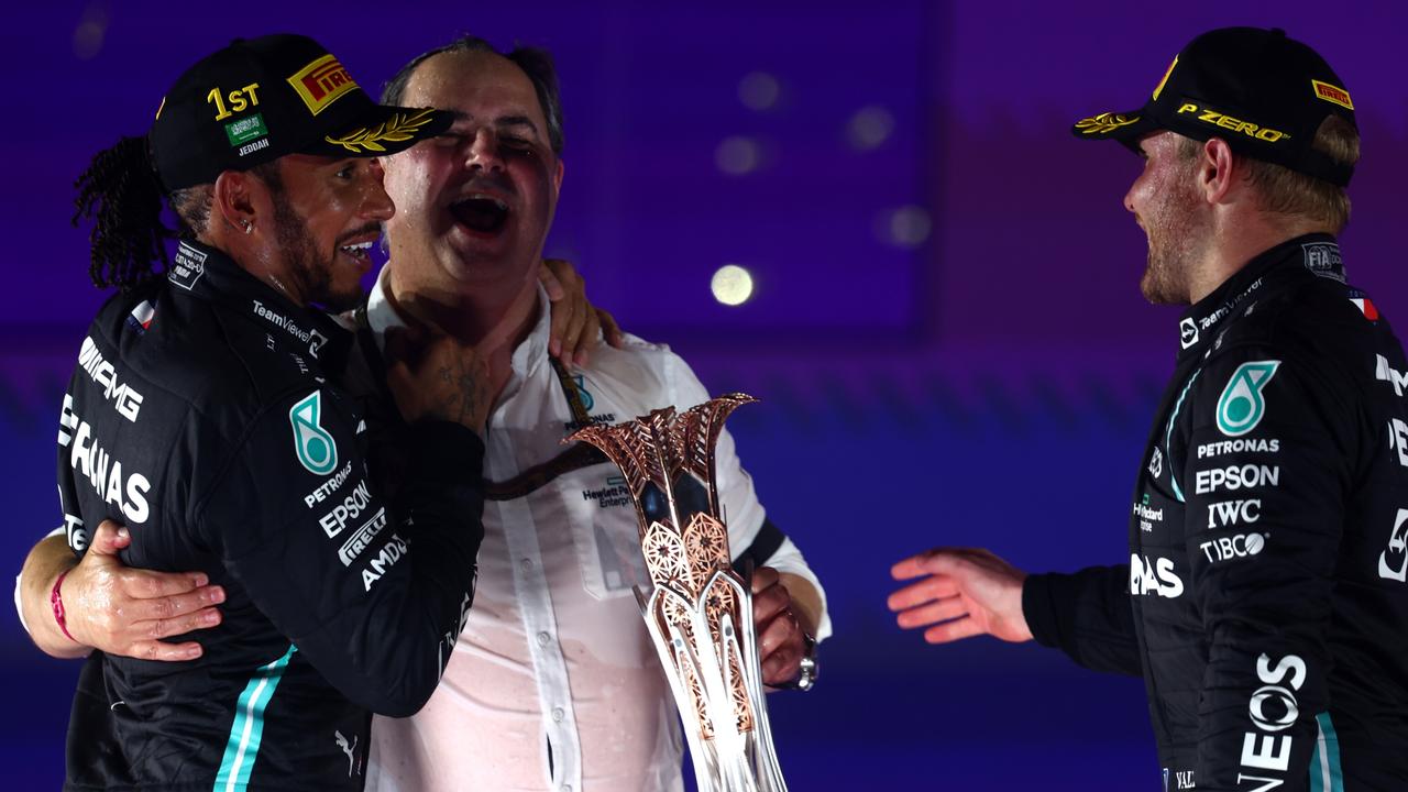 Race winner Lewis Hamilton of Mercedes and teammate Valtteri Bottas celebrate with Ron Meadows, Sporting Director of Mercedes GP on the podium after the F1 Grand Prix of Saudi Arabia on December 05, 2021. (Photo by Mark Thompson/Getty Images)