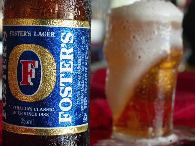 p44// A bottle of Foster's beer near a freshly poured glass of beer on a bar of a hotel in Sydney, Feb 10, 2004. REUTERS PicWill/Burgess Fosters label