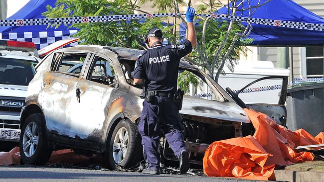 A police officer examines the remains of Hannah Baxter’s burnt out SUV. Picture: AAP/John Gass