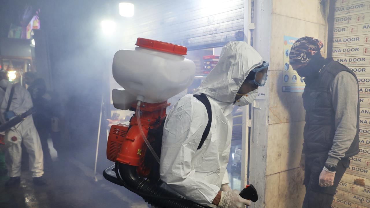 Firefighters disinfect a traditional shopping centre in northern Tehran. Picture: AP/Ebrahim Noroozi