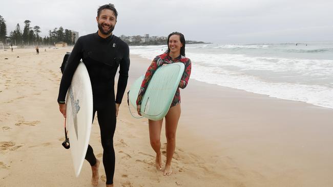 Sam Phillips and partner Kate Thomas surfing at Manly in Sydney on Monday. Picture: Nikki Short