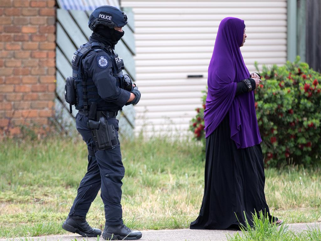Special Op personnel outside the home of the parents of the Bourke Street attacker. A women is turned away after she requested that she visit the residents of the home. Picture: Sarah Matray