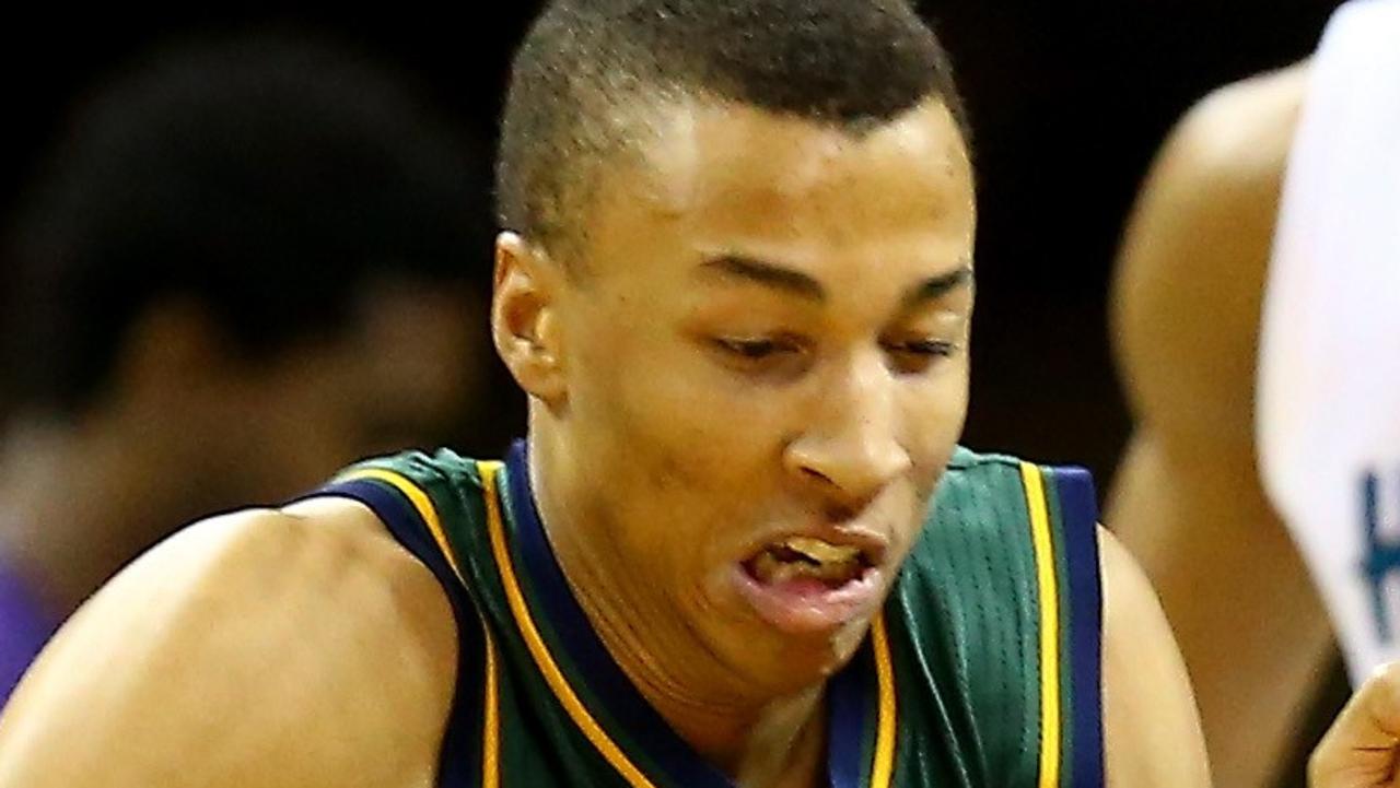 CHARLOTTE, NC - DECEMBER 20: Dante Exum #11 of the Utah Jazz and Kemba Walker #15 of the Charlotte Hornets go after a loose ball during their game at Time Warner Cable Arena on December 20, 2014 in Charlotte, North Carolina. NOTE TO USER: User expressly acknowledges and agrees that, by downloading and or using this photograph, User is consenting to the terms and conditions of the Getty Images License Agreement. Streeter Lecka/Getty Images/AFP == FOR NEWSPAPERS, INTERNET, TELCOS & TELEVISION USE ONLY ==