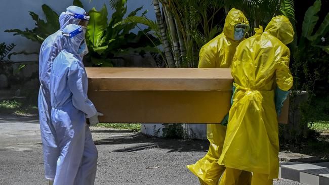 Workers carry a cardboard coffin of a Covid-19 victim for cremation at a cemetery in Colombo, Sri Lanka. Picture: AFP