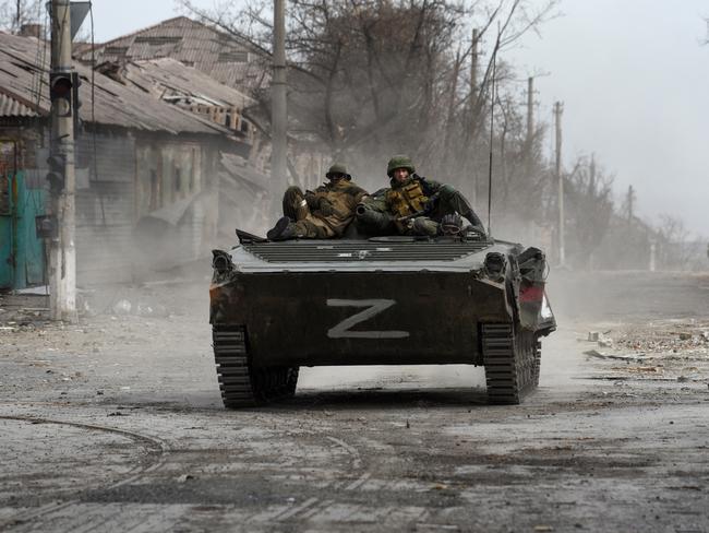 Service members of pro-Russian troops sit atop of an armoured vehicle, which moves along a street in the course of Ukraine-Russia conflict in the southern port city of Mariupol. Picture: Supplied