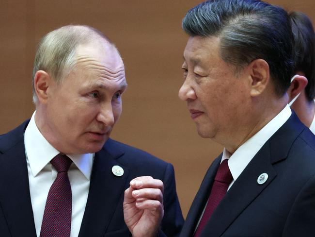 Russian President Vladimir Putin speaks to China's President Xi Jinping during the Shanghai Cooperation Organisation (SCO) leaders' summit in Samarkand on September 16, 2022. (Photo by Sergei BOBYLYOV / SPUTNIK / AFP)