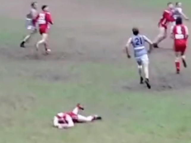 A Mount Lofty player lies motionless on the ground after being hit off the ball by a Hahndorf player. He was hospitalised.