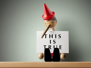 Pinocchio holding sheet of paper. ISTOCK