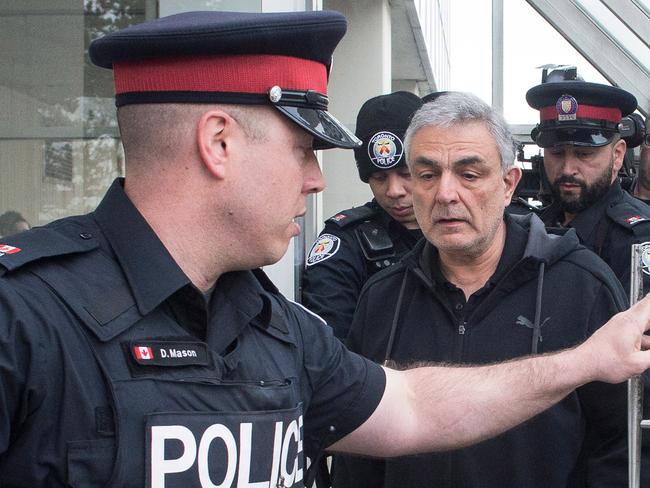 Vahe Minassian surrounded by members of the media as he leaves court with a police escort. Picture: Chris Young/The Canadian Press via AP