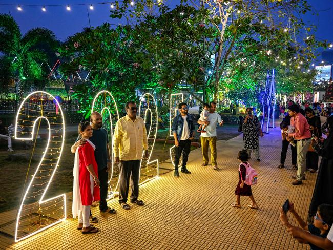 People pose for photographs at the illuminated sea promenade on New Year's Eve, in Mumbai on December 31, 2024. Picture: AFP