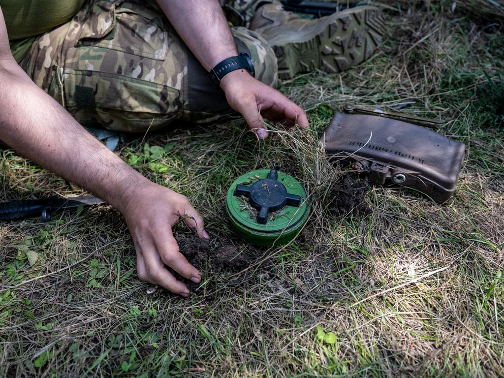 A Ukrainian de-mining sapper demonstrates how Russian forces place an anti-personnel mine on top of a fragmentation grenade. Picture: Getty Images