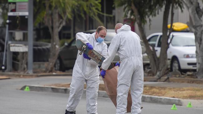 Police remove the victim’s skateboard from the Welland street. Picture: RoyVphotography