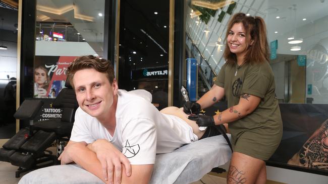 Daniel Gorringe getting a tattoo of Suns coach Stuart Dew. Picture: Richard Gosling