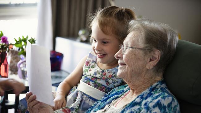 St Paul’s Aged Care resident Olive Reynolds reads to Melody Webber.