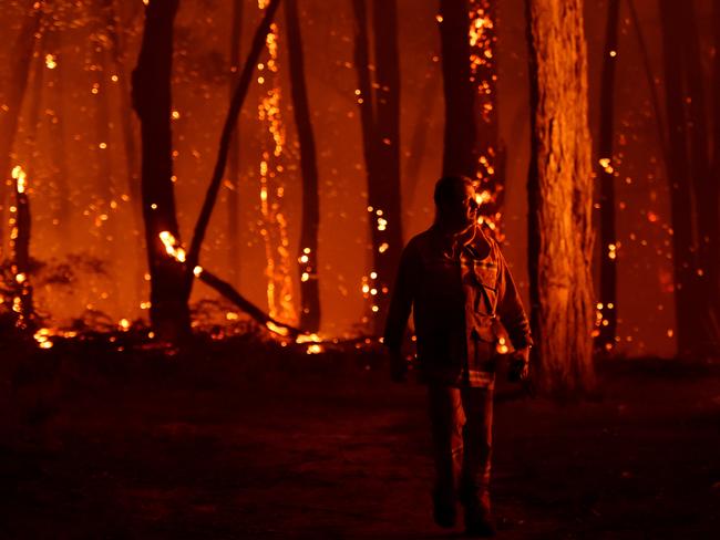 Locals look at spot fires in bushland near their property in Benloch. Picture: AAP